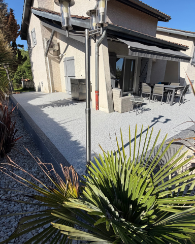 Terrasse extérieure recouverte d'un revêtement de sol en résine grise mouchetée, réalisée par CMG LYON